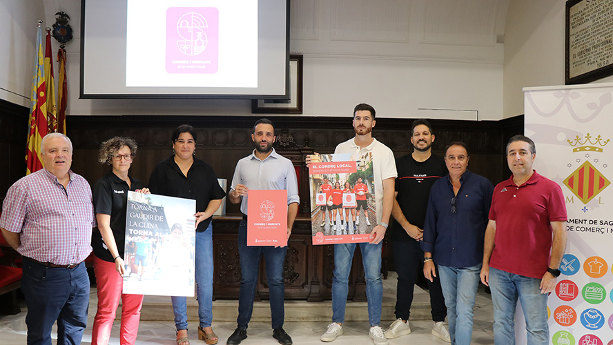 Vicky Sevilla i les jugadores i jugadors dels equips d'handbol de la ciutat, amb el comerç de Sagunt